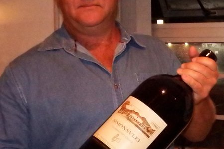 Leon Engkle (links) ontvang die bottel wyn nadat die bod (R2,000) op hom toegeslaan is